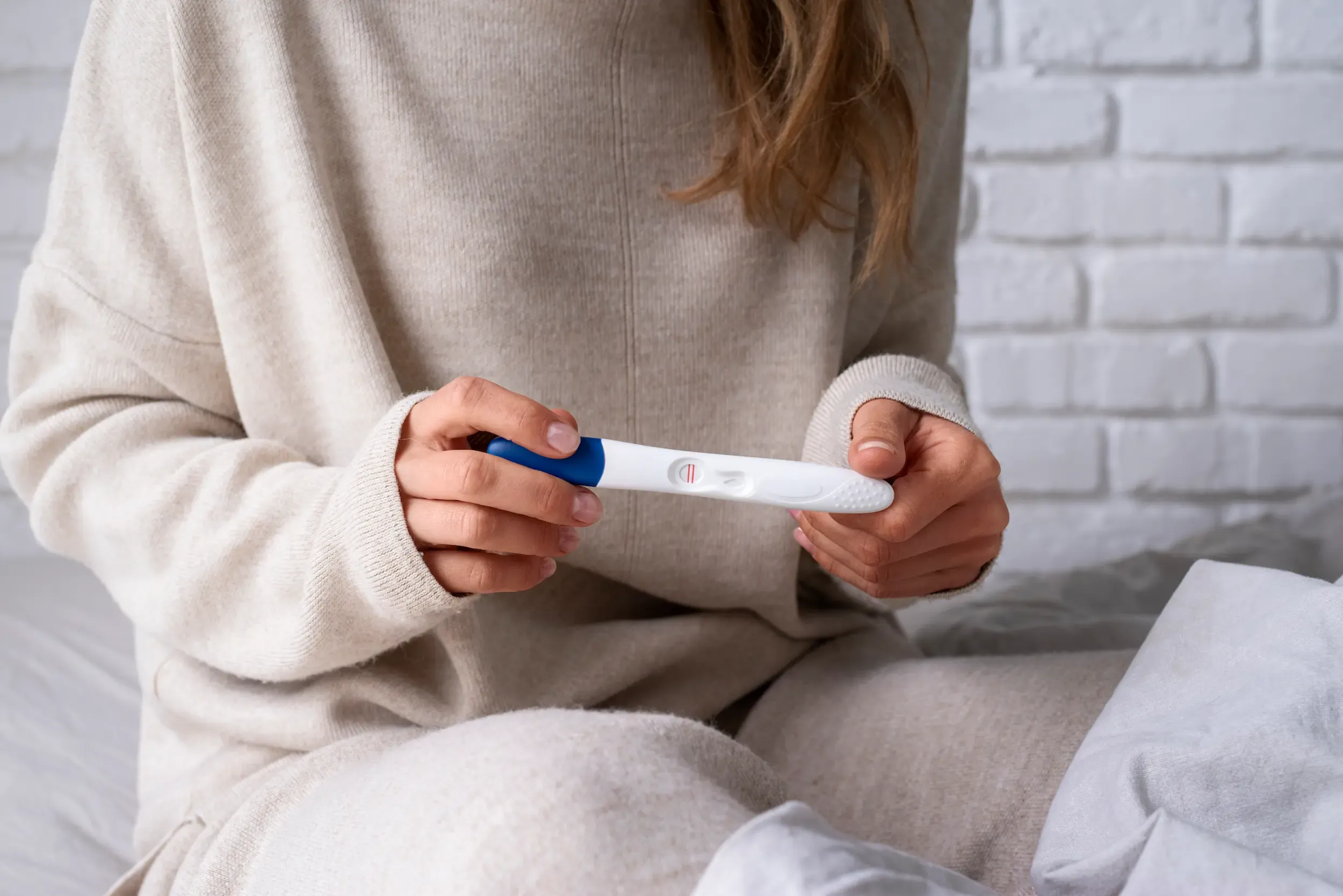 front-view-woman-holding-positive-pregnancy-test.webp