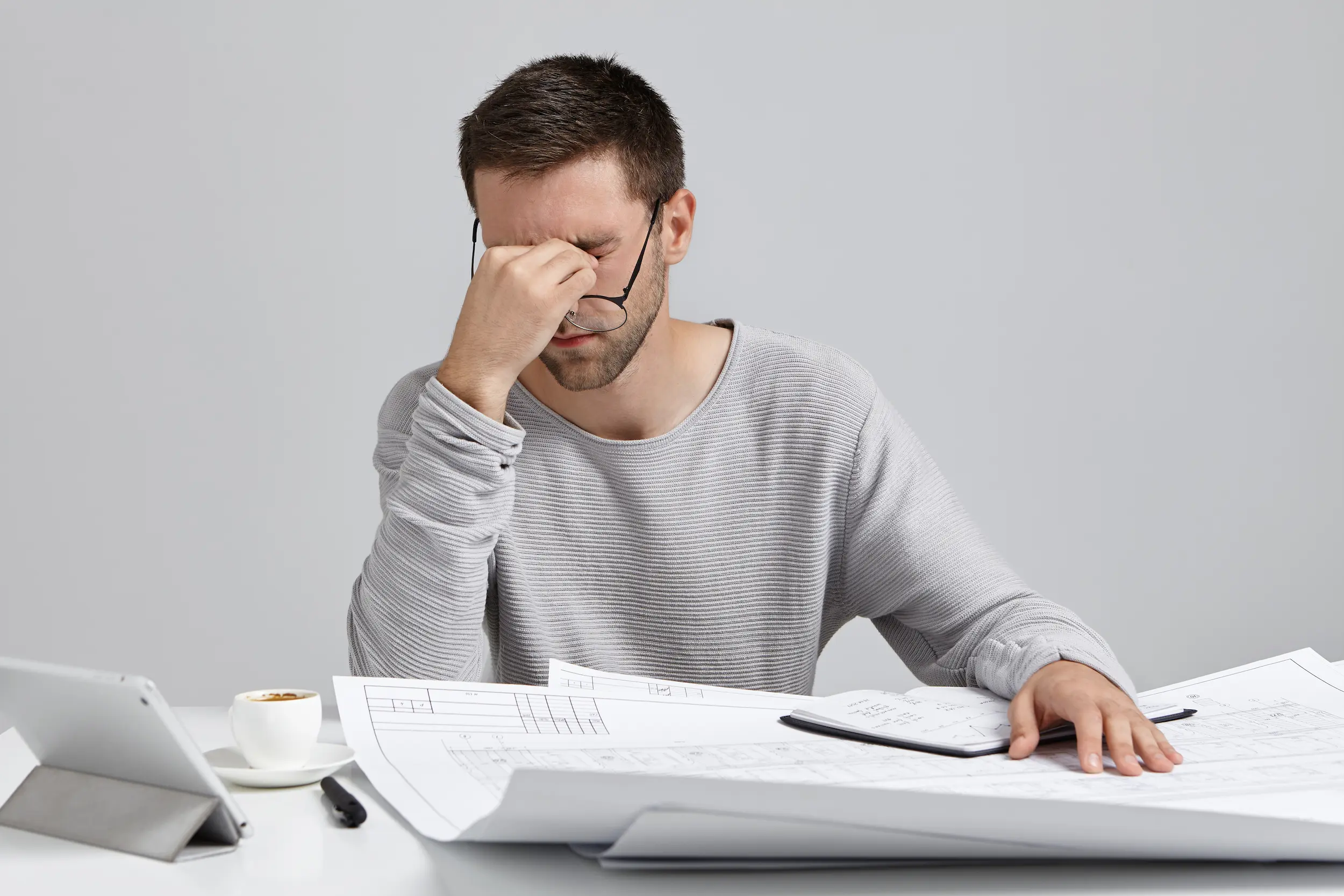 young-man-sitting-desk-doing-paperwork.webp